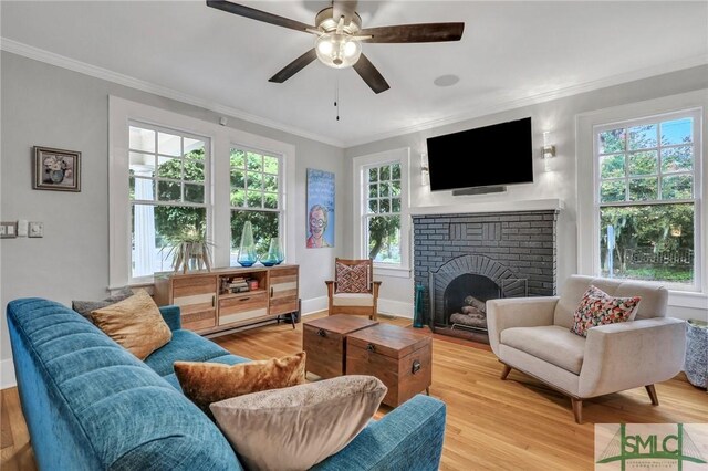 living room with a wealth of natural light, light wood-type flooring, and a fireplace