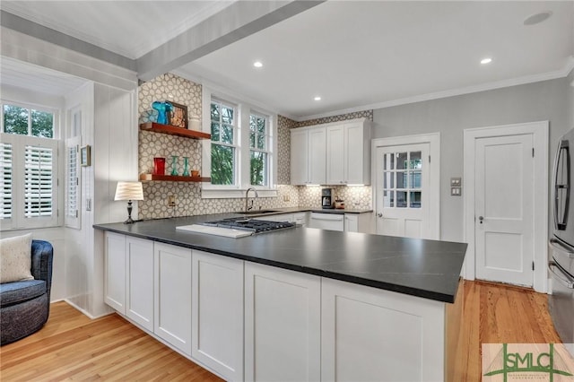 202 E 51st St, Savannah, GA 31405 - kitchen featuring a peninsula, light wood-style floors, backsplash, ornamental molding, and dark countertops
