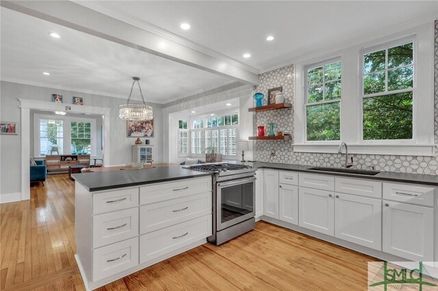 202 E 51st St, Savannah, GA 31405 - kitchen with stainless steel gas range oven, a sink, dark countertops, ornamental molding, and light wood-style floors