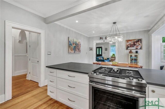202 E 51st St, Savannah, GA 31405 - kitchen with gas stove, dark countertops, white cabinetry, light wood-type flooring, and a chandelier