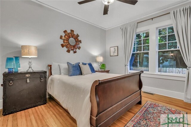 bedroom with crown molding, ceiling fan, and hardwood / wood-style flooring