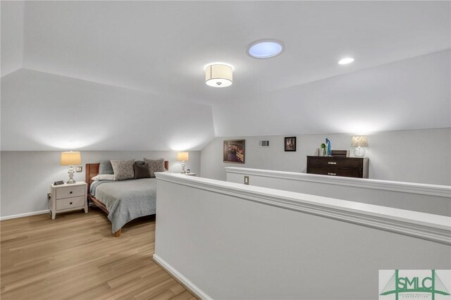 bedroom featuring vaulted ceiling and light hardwood / wood-style floors