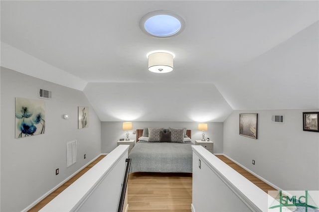 bedroom featuring light hardwood / wood-style floors and vaulted ceiling