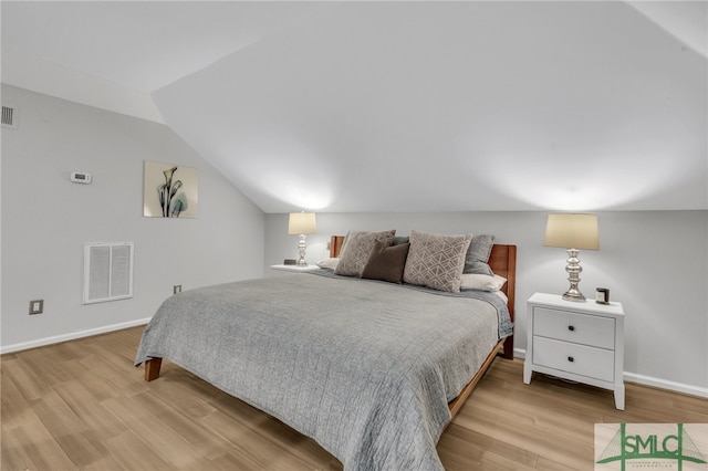 bedroom with lofted ceiling and light hardwood / wood-style floors