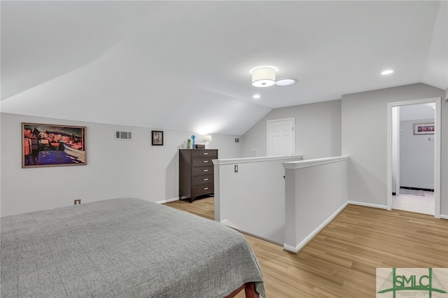 bedroom with lofted ceiling and light hardwood / wood-style floors