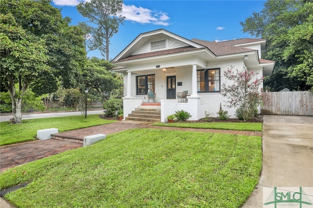 view of front of property featuring covered porch and a front lawn