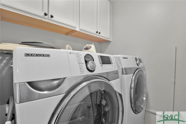 laundry area with cabinets and washing machine and clothes dryer