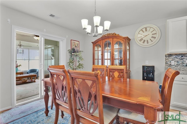 dining area featuring ceiling fan with notable chandelier