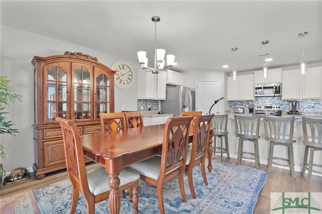 dining room featuring a chandelier and light wood-type flooring