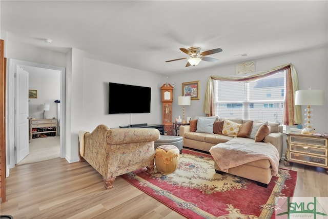 living room with ceiling fan and light hardwood / wood-style flooring