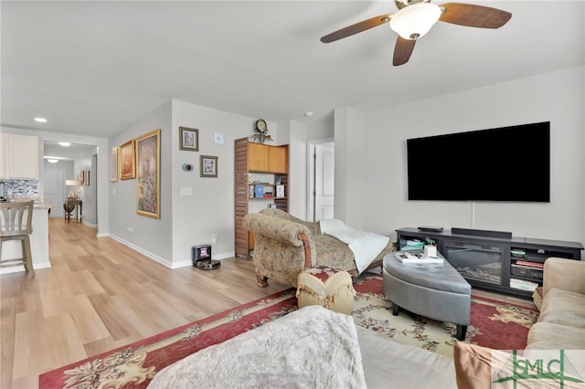 living room with light hardwood / wood-style floors and ceiling fan