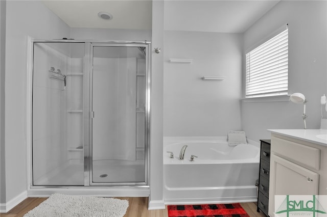 bathroom featuring plus walk in shower, hardwood / wood-style floors, and vanity