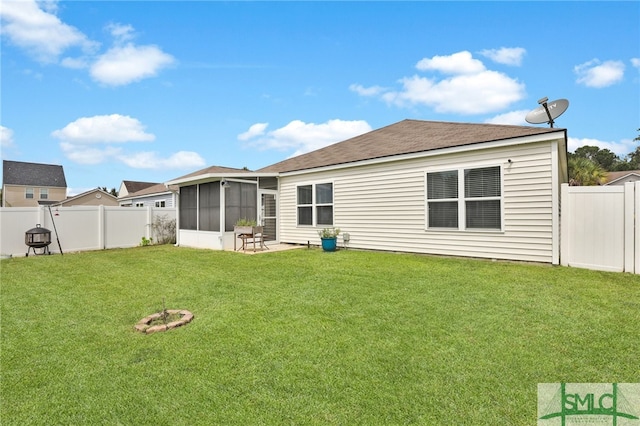 back of house featuring a sunroom, a yard, and a patio