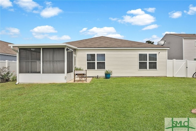 back of house with a lawn, a sunroom, and a patio