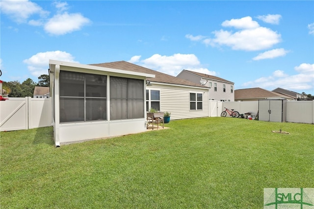 back of property with a lawn and a sunroom