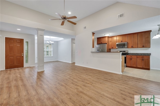 kitchen with hanging light fixtures, ceiling fan with notable chandelier, stainless steel appliances, light hardwood / wood-style floors, and decorative columns