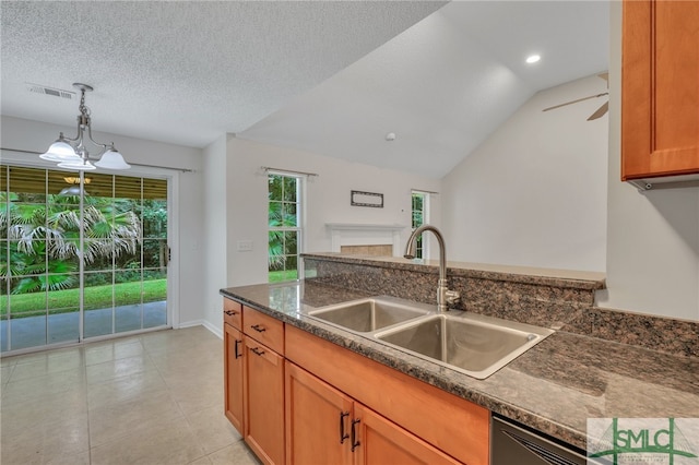 kitchen with ceiling fan with notable chandelier, sink, lofted ceiling, pendant lighting, and a textured ceiling