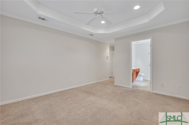 carpeted spare room featuring ceiling fan, a raised ceiling, and ornamental molding