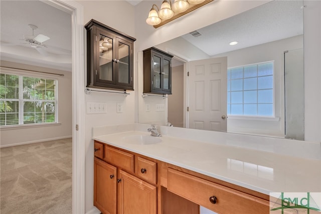 bathroom with a textured ceiling, vanity, and ceiling fan