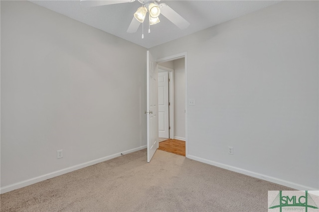 carpeted spare room with ceiling fan