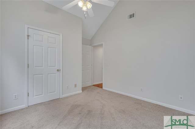 unfurnished bedroom featuring light carpet, high vaulted ceiling, and ceiling fan