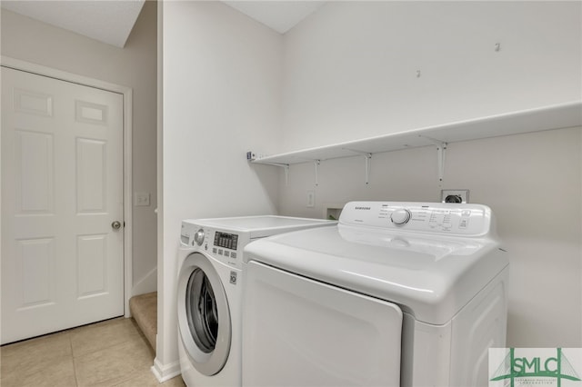 washroom with washer and clothes dryer and light tile patterned floors