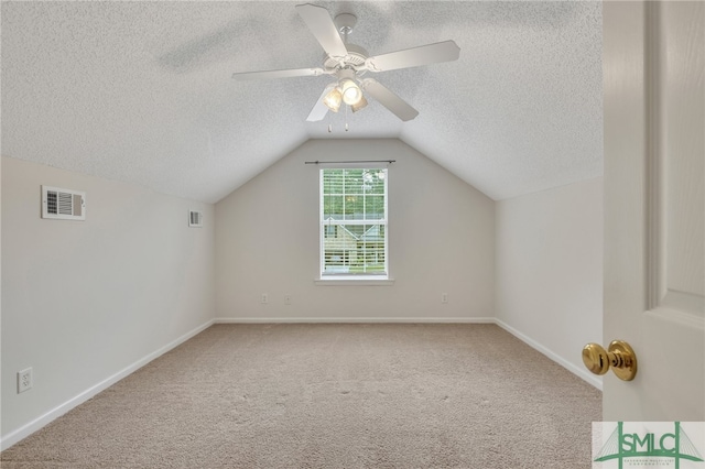 bonus room featuring vaulted ceiling, a textured ceiling, ceiling fan, and carpet