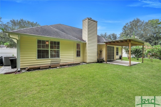 rear view of property featuring a patio area, a lawn, and central AC