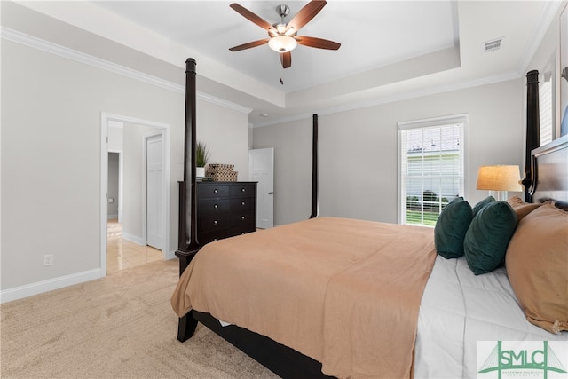 bedroom with crown molding, light colored carpet, a tray ceiling, and ceiling fan