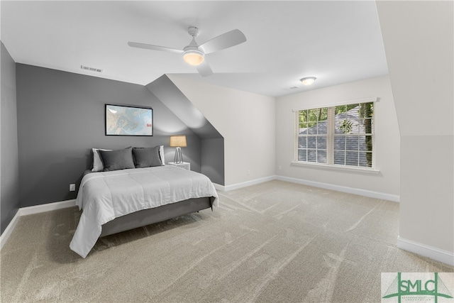 carpeted bedroom with ceiling fan and vaulted ceiling