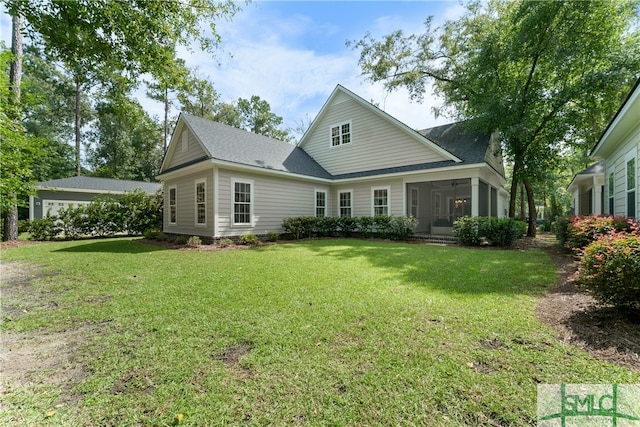 rear view of house with a yard and a sunroom