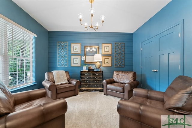 carpeted living room featuring wood walls and a notable chandelier