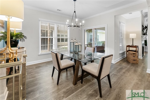 dining space featuring ornamental molding, an inviting chandelier, and dark hardwood / wood-style floors