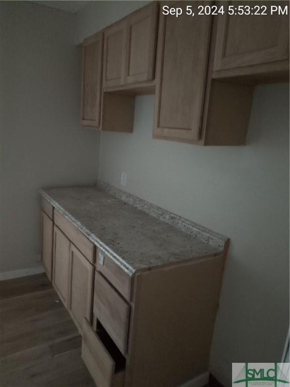 kitchen with dark wood-type flooring and light brown cabinets