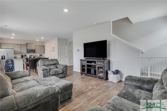 living area featuring recessed lighting, baseboards, and light wood-style floors