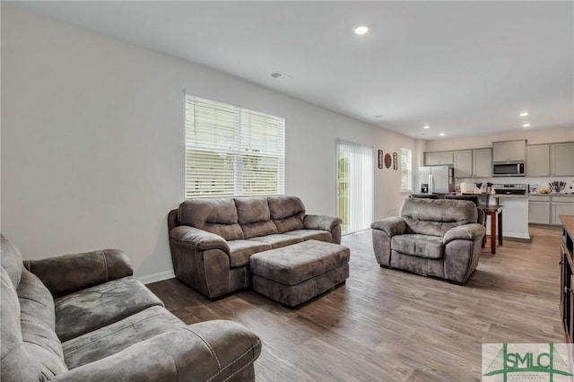 living room with visible vents, recessed lighting, baseboards, and wood finished floors