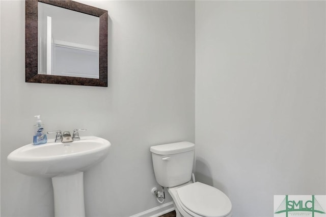 bathroom featuring toilet and baseboards