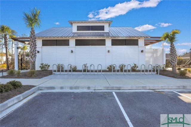 view of front of property featuring metal roof, a standing seam roof, and uncovered parking