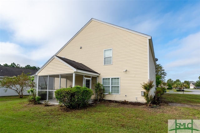 back of property featuring a lawn and a sunroom