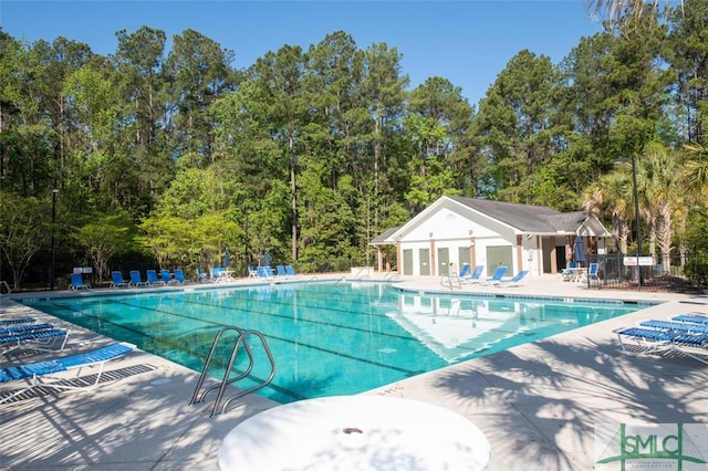 view of swimming pool featuring an outdoor structure and a patio