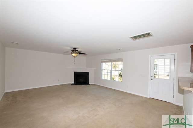 unfurnished living room featuring light carpet and ceiling fan