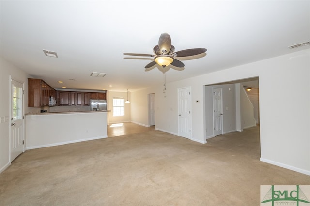 unfurnished living room featuring light colored carpet and ceiling fan