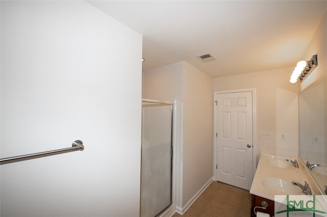 bathroom featuring vanity, a shower with shower door, and tile patterned flooring