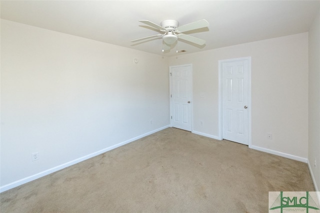 carpeted spare room featuring ceiling fan