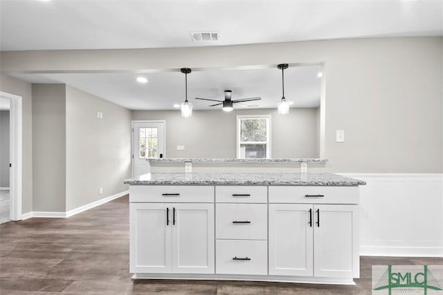 kitchen featuring ceiling fan, decorative light fixtures, white cabinetry, and light stone countertops