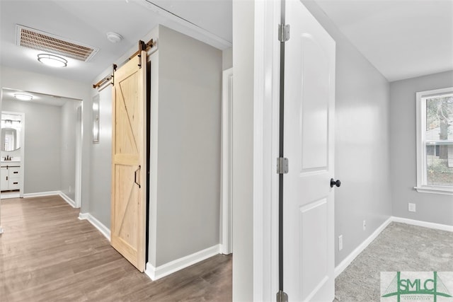 hallway with hardwood / wood-style flooring and a barn door