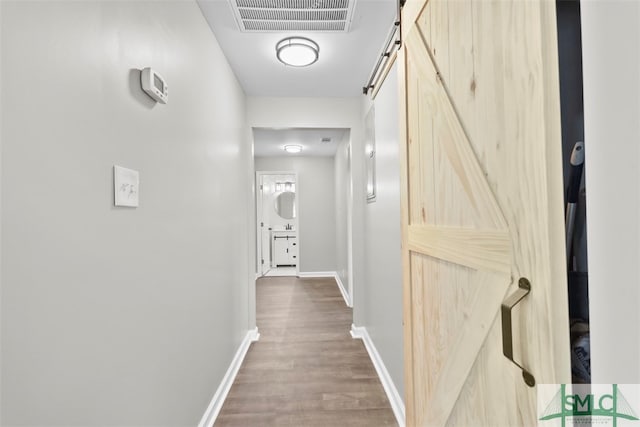 hall featuring hardwood / wood-style flooring and a barn door