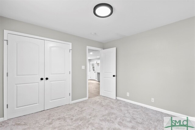 unfurnished bedroom with a closet and light carpet