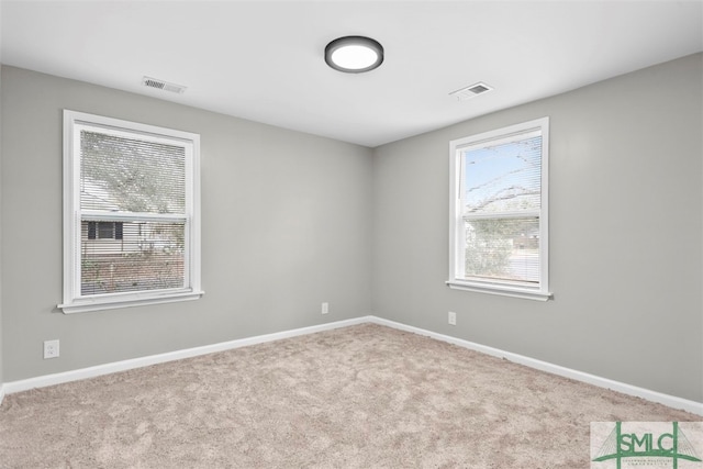 empty room with plenty of natural light and light colored carpet