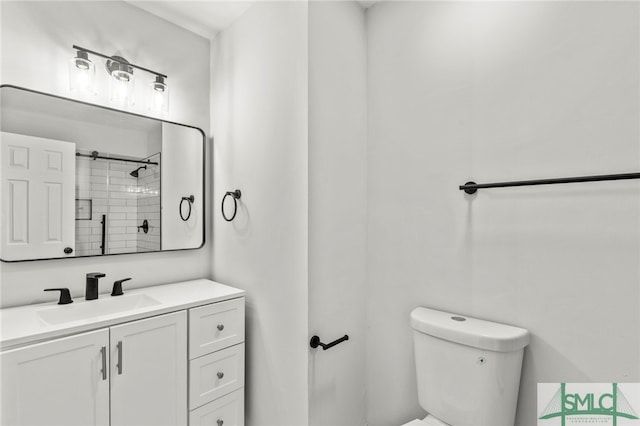 bathroom with vanity, toilet, and a tile shower